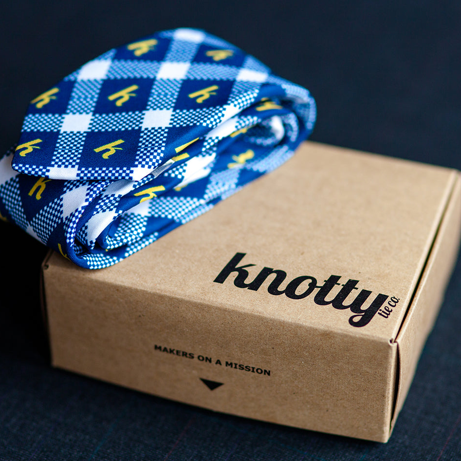 branded necktie rolled and placed on top of a Knotty Tie kraft gift box