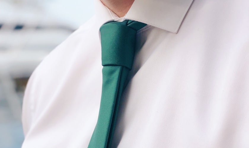 Man wearing white dress shirt with solid green necktie