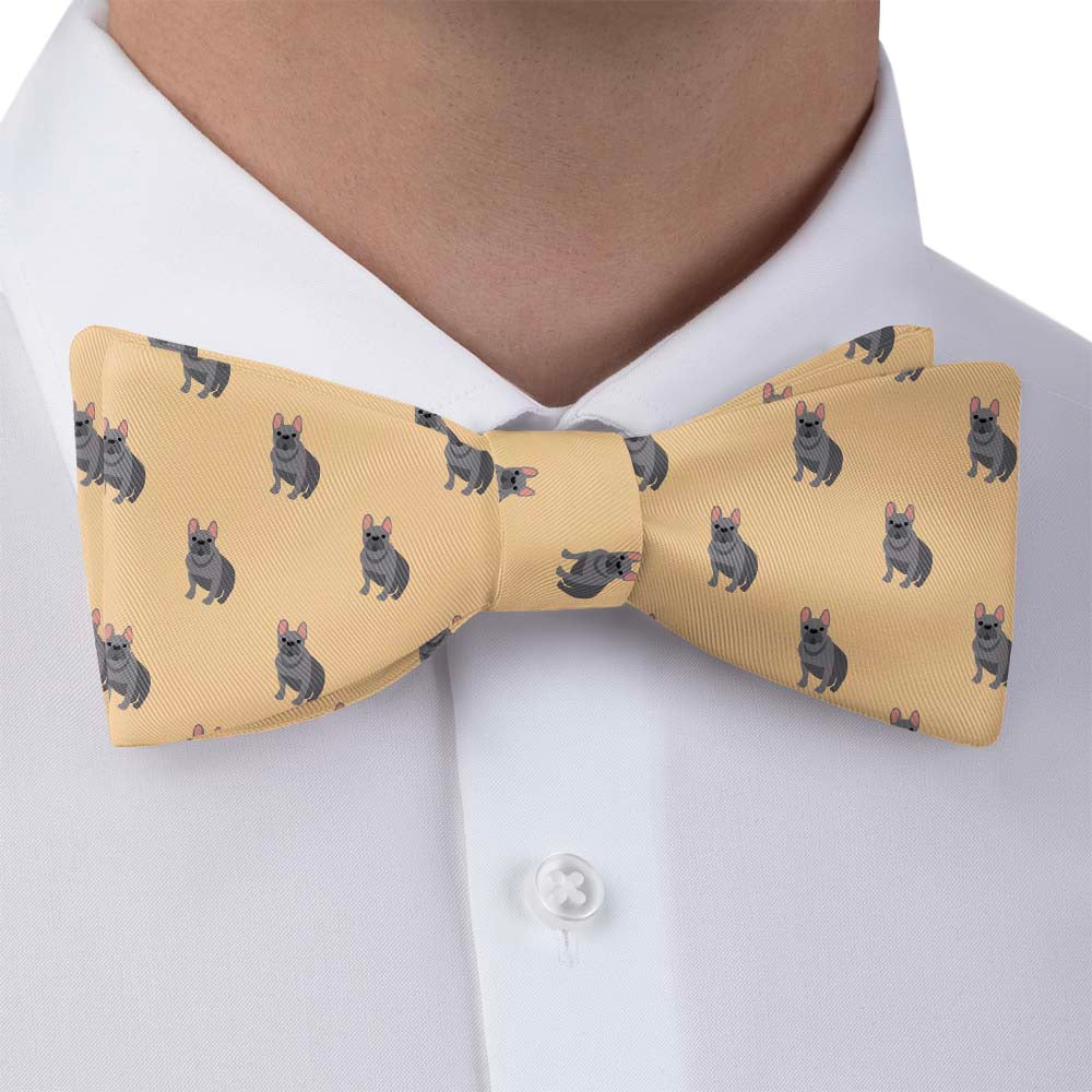 Yellow bow tie with dog pattern worn by a person in a white shirt.