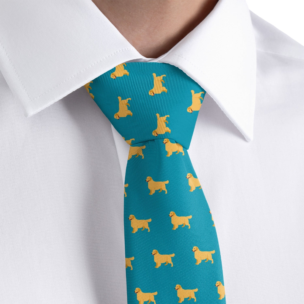 Teal tie with yellow dog pattern worn by a person in a white shirt.