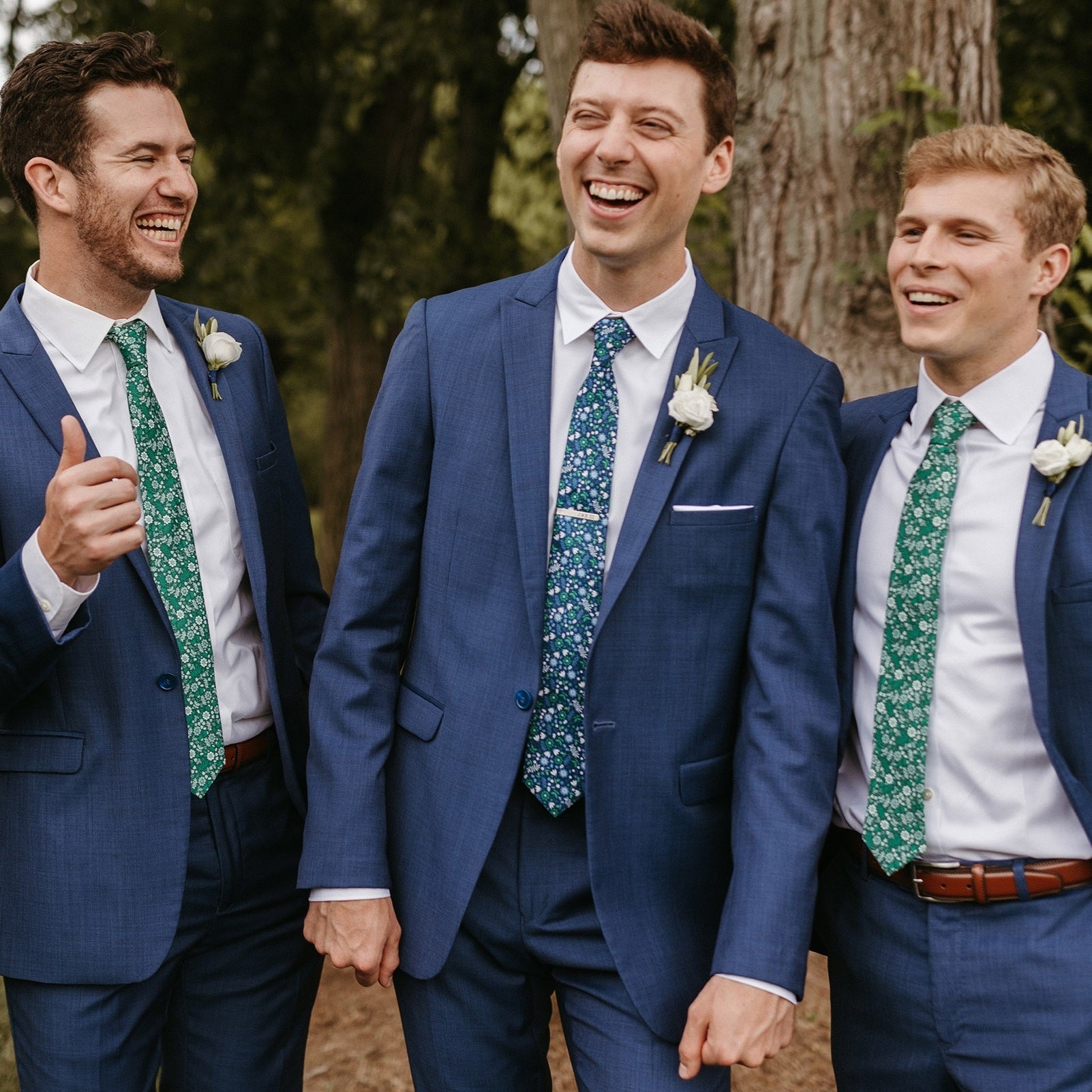 customized floral neckties being worn by three men in navy suits