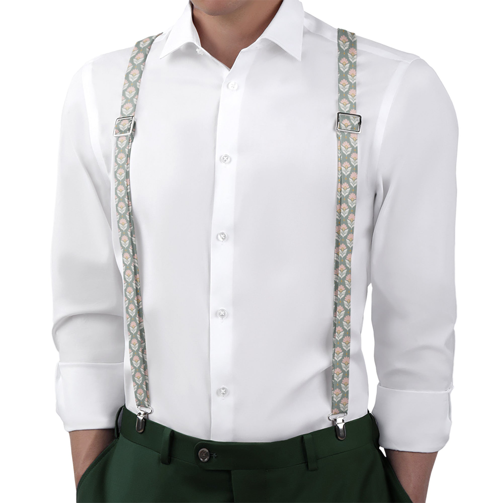 Person wearing a white shirt with patterned suspenders and green pants on a white background