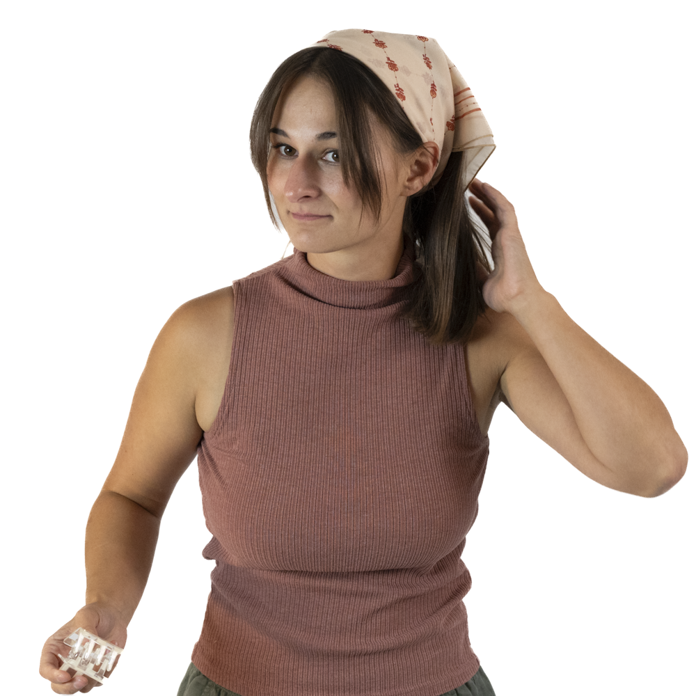A woman letting her hair down while wearing a square scarf as a headscarf