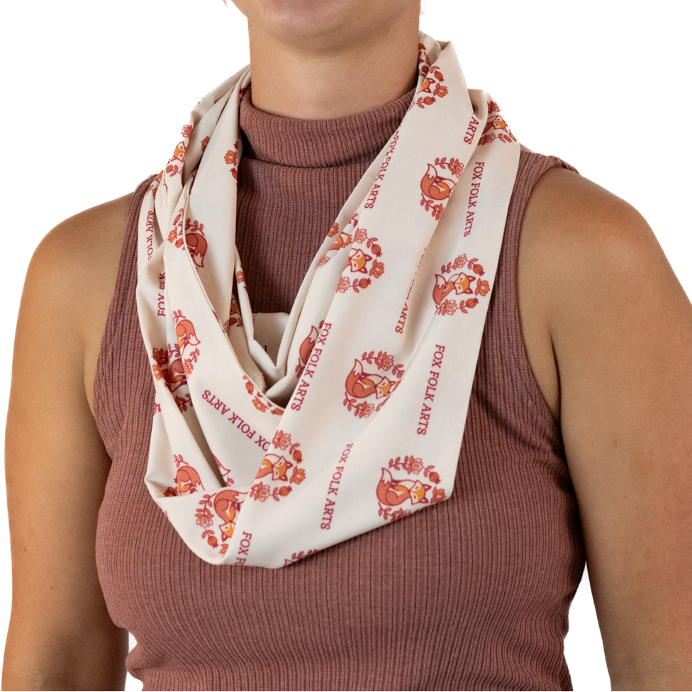 A woman wearing a cream-colored infinity scarf in a double loop