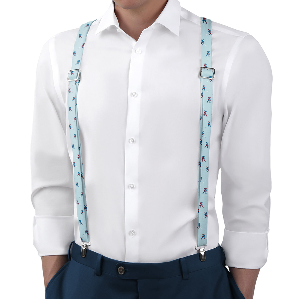 Person wearing a white shirt and blue patterned suspenders on a white background