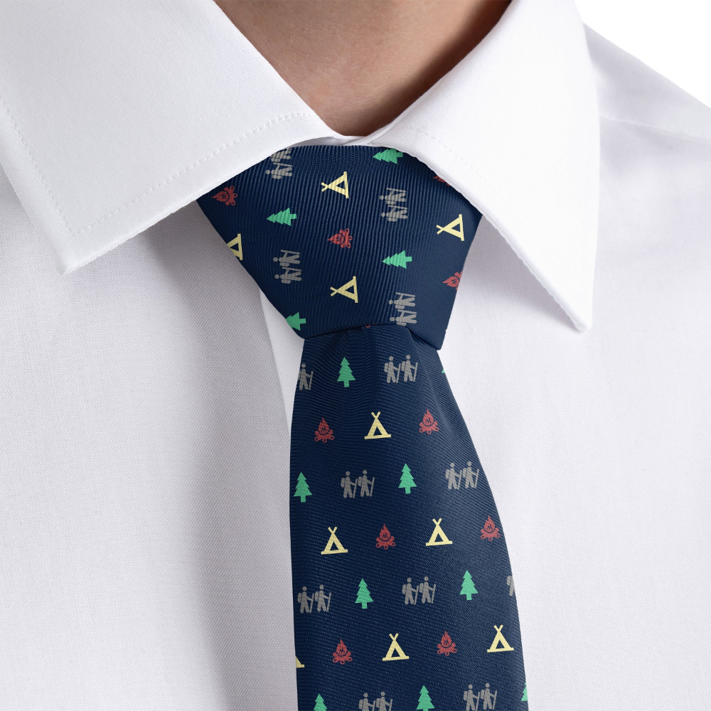 Navy tie with colorful patterns worn by a person in a white shirt.