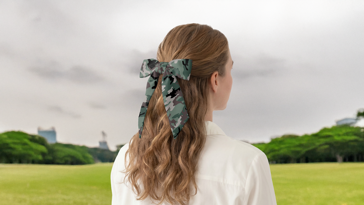 Person with a camouflage scarf in their hair standing in a park