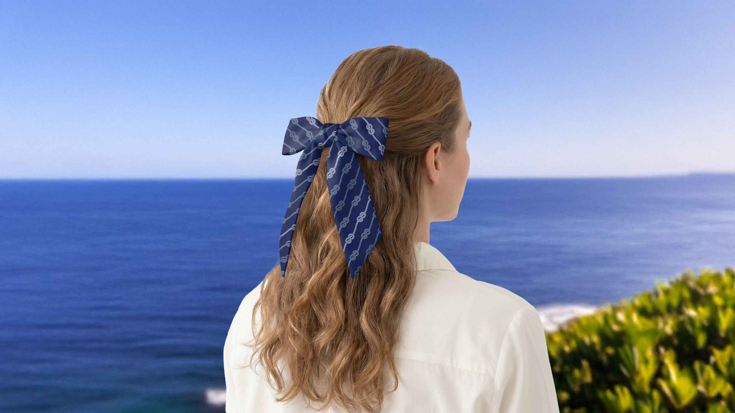 Woman with a blue scarf in her hair looking at the water