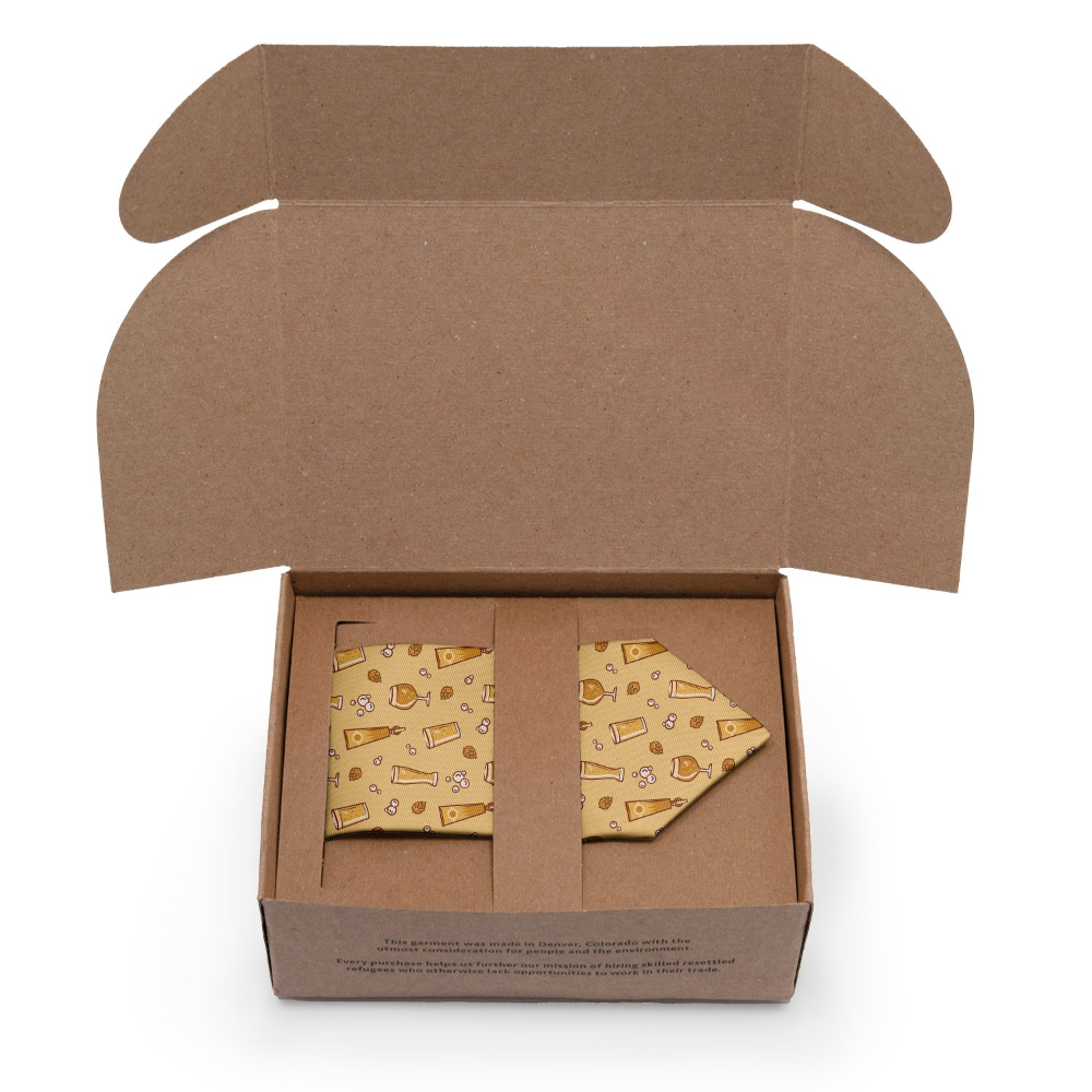 Open kraft box with a patterned tie inside on a white background