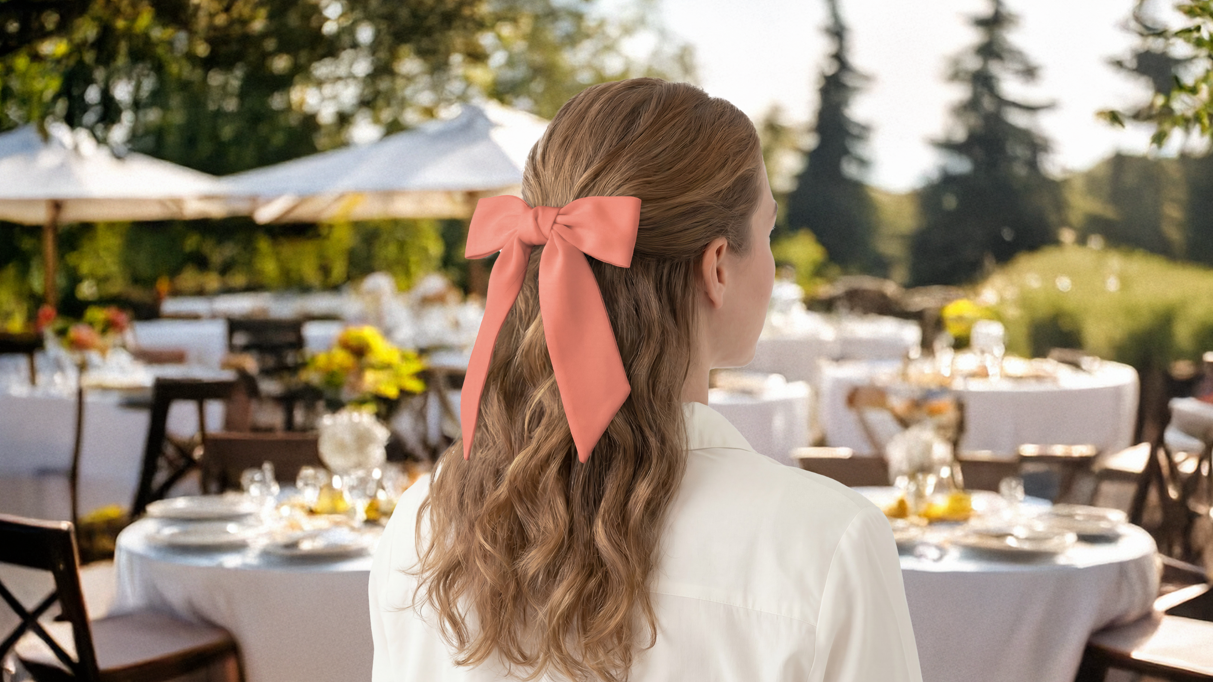 Woman with an orange scarf bow in her hair standing in an outdoor setting with tables and chairs.