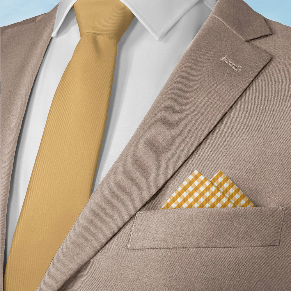 Brown suit jacket with a yellow tie and matching plaid pocket square on a light blue background