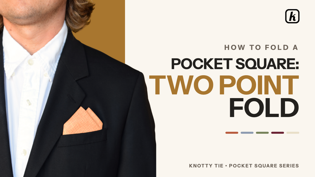Load video: The video outlines the steps to perform a "two-point fold" for a pocket square, a technique designed to conceal the unprinted side of the fabric. This fold is recommended for formal occasions like weddings and black-tie events, though it is not ideal for displaying a specific logo.Step-by-Step Instructions:Initial Setup: Lay the pocket square flat in a diamond shape with the printed side facing down and one point directed toward you.Creating the Triangle: Fold the bottom point up to meet the top point to create a triangle. Next, fold the left point over to the right point to form a smaller triangle, smoothing out any wrinkles. Establishing the Fold Line: Identify the lower-left corner and place a finger approximately one inch above it to mark the fold line.Refining the Shape: Take the top-left corner and fold it down toward the bottom-right, aligning the edge with your mark. This results in a triangle resting above a one-inch strip of fabric.Finalizing the Peaks: Fold the left corner over to meet the right corner, ensuring the edges are aligned. Rotate the square so the long, stitched edge is at the bottom. Adjust the two folded peaks so they are spaced appropriately.Pocket Insertion: Fold the remaining left and right corners behind the peaks to match the width of your breast pocket. Place the square into the pocket, allowing the two points to show.