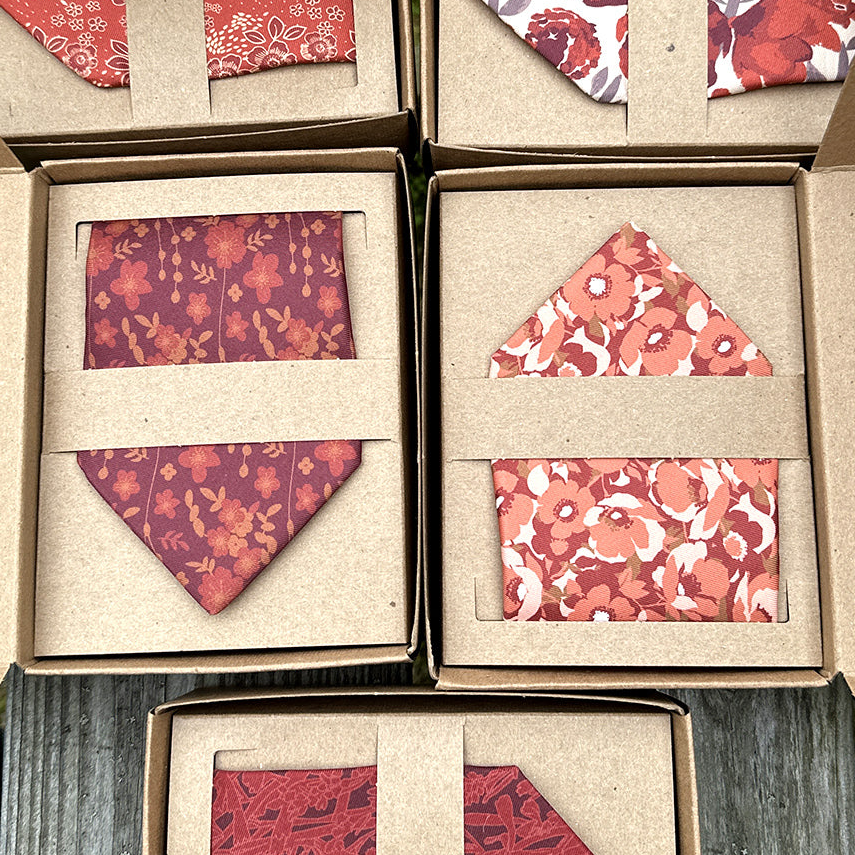 Floral-patterned fabric pieces in cardboard boxes on a wooden surface