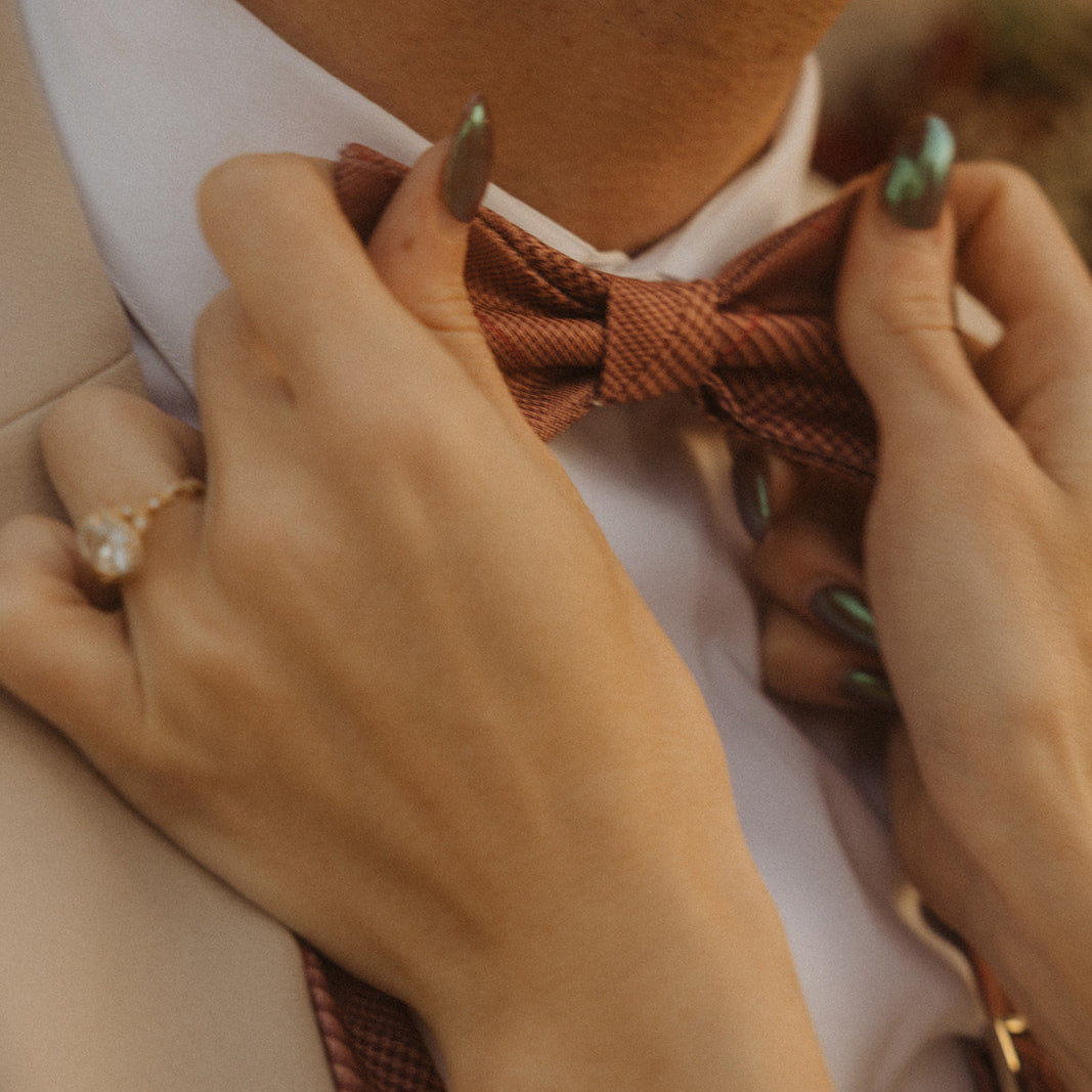 Pre tied bow tie being grabbed by bride