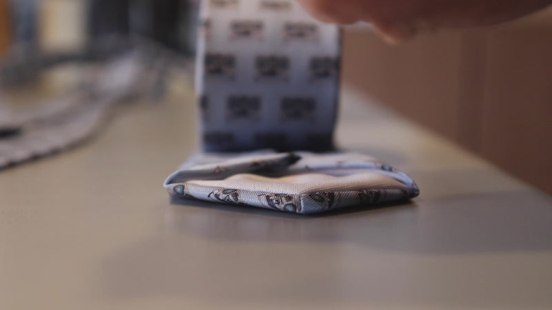 person rolling a necktie