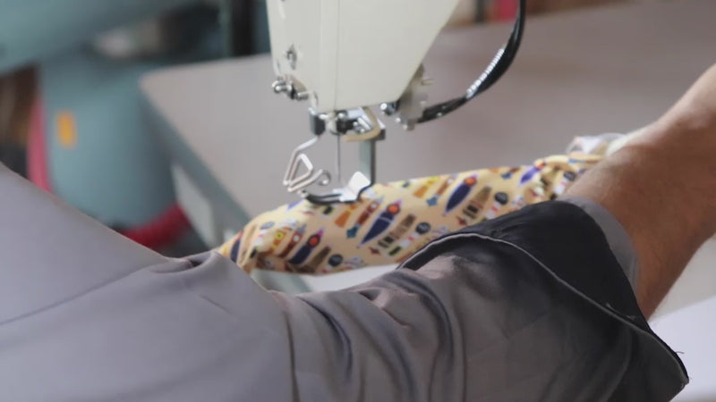 Custom Ties being manufactured and knotty logo tag being sewn onto the back