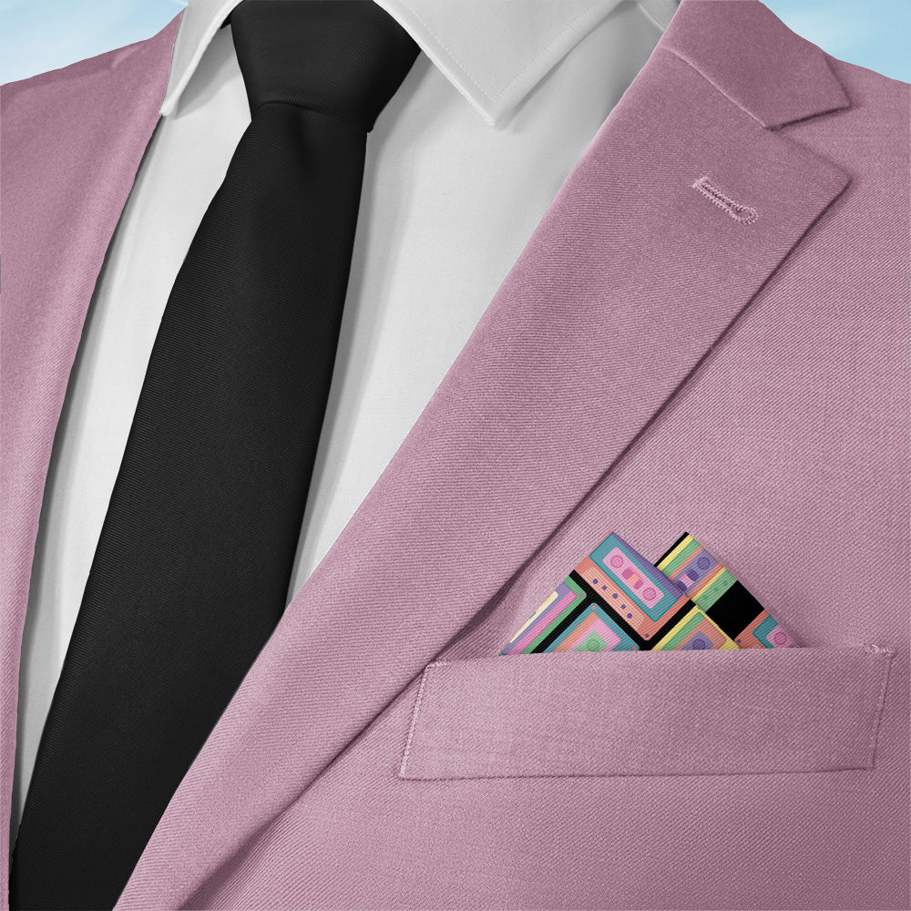Pink blazer with a black tie and colorful retro pocket square on a light blue background
