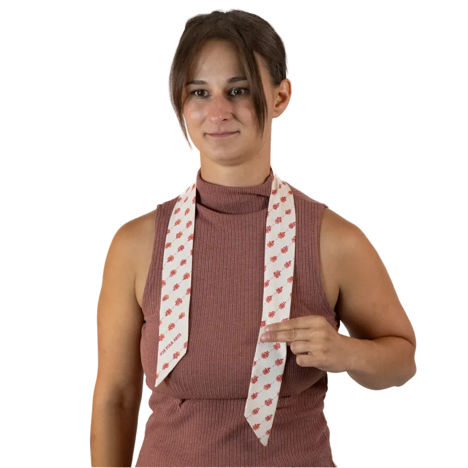 A woman with a cream skinny scarf around her neck, positioned to be longer on one side