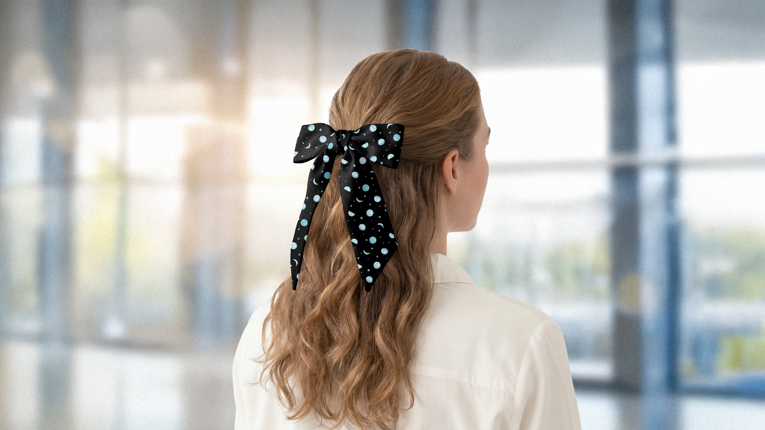 Person with a polka dot hair scarf in a blurred indoor setting