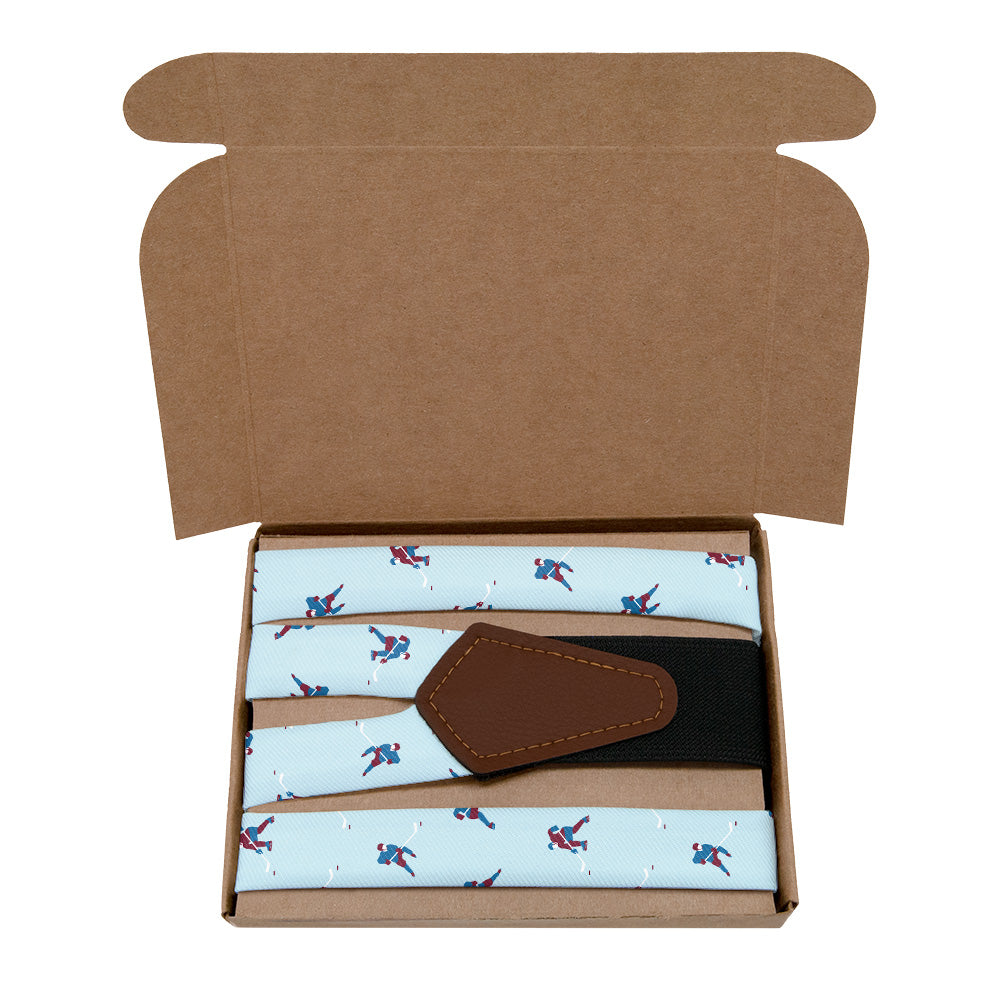 Open cardboard box containing a patterned tie and brown leather Y-back on a white background