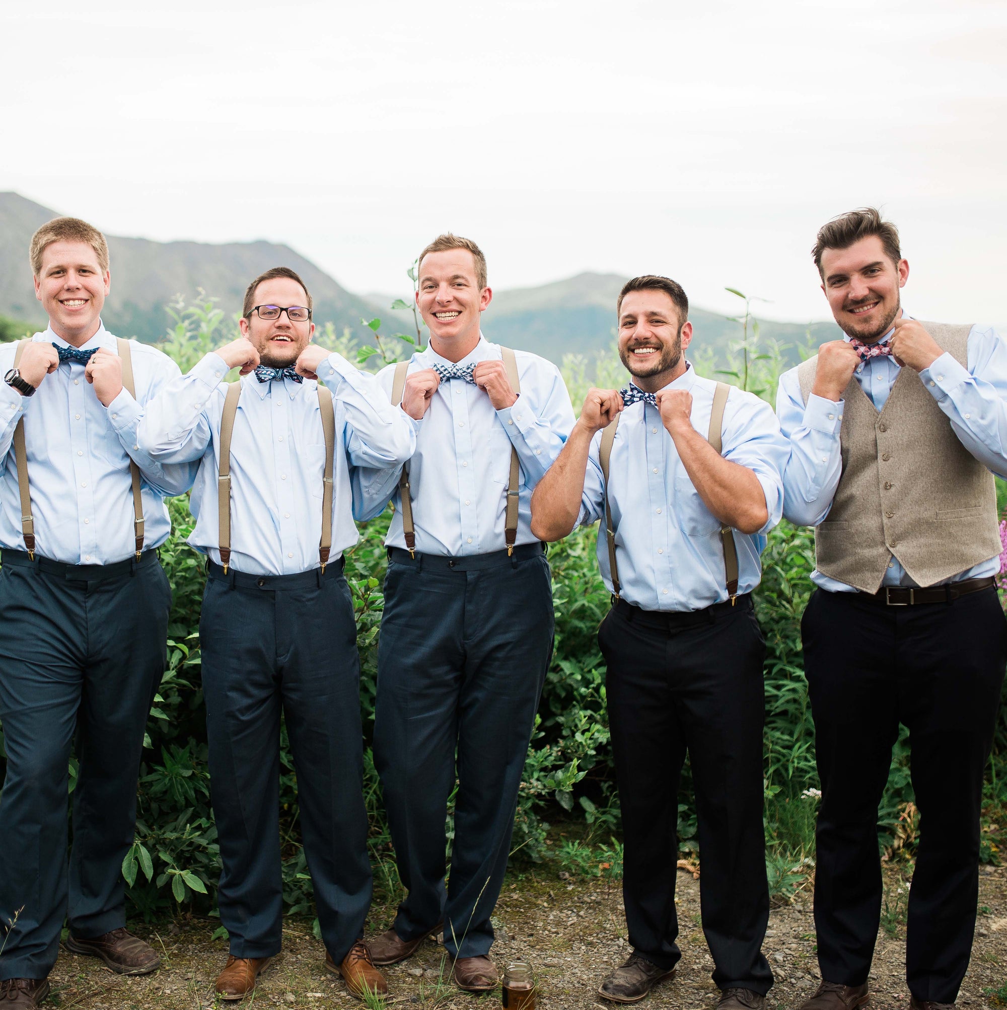 Custom bow ties on groomsmen standing in an outdoor setting