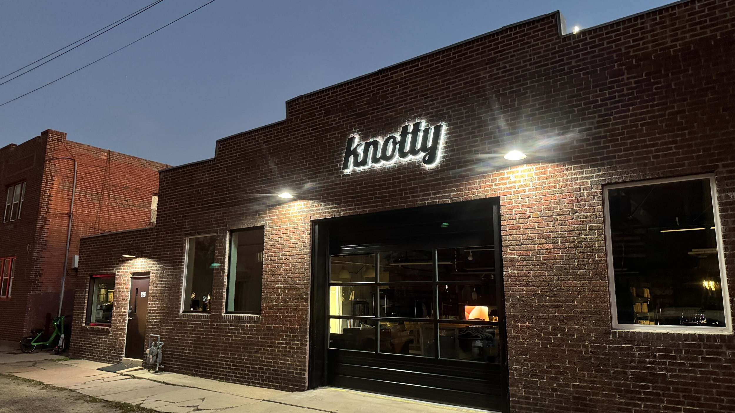 Brick building with 'knotty' sign at night