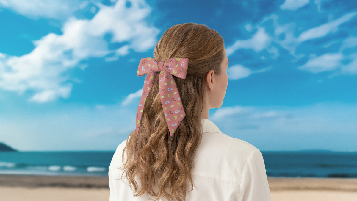 Woman with a pink hair scarf looking at the ocean